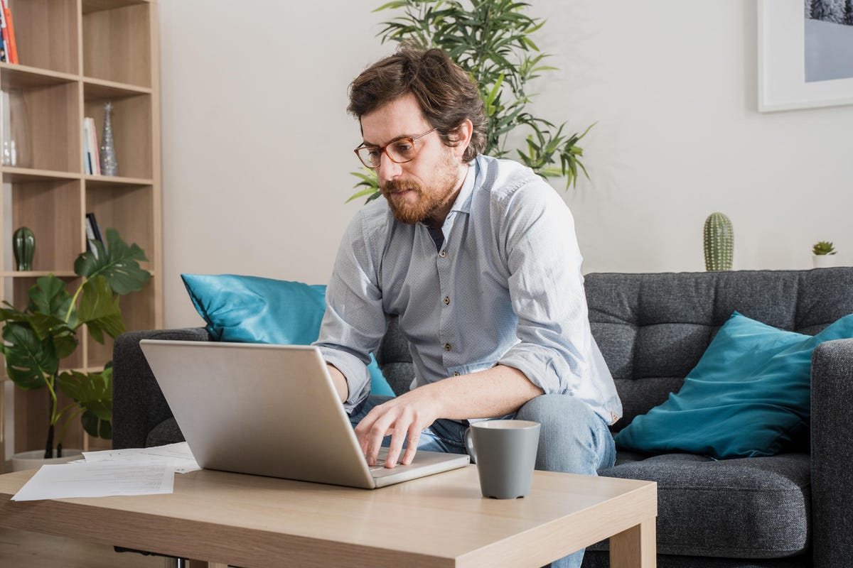 Male businessman working on laptop from home