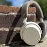 Sennheiser Momentum 4 wireless headphones against red brick