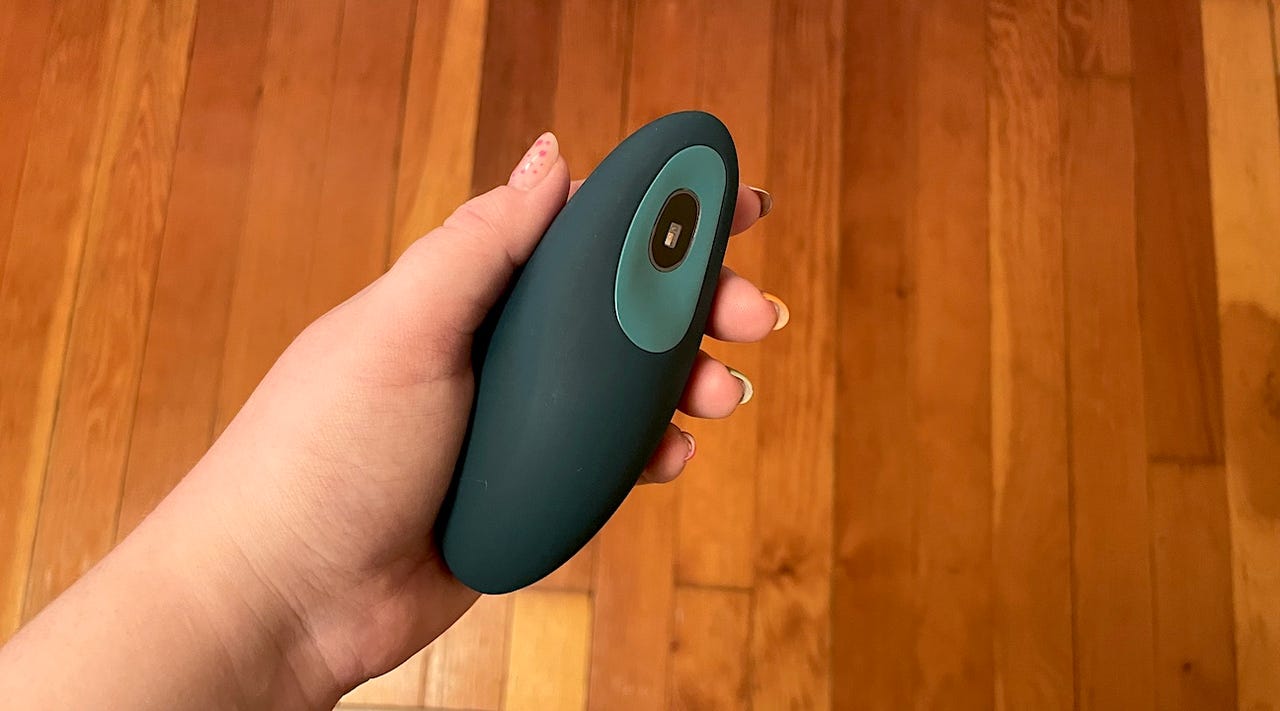 Person holding a blue/green meditation device in their hand