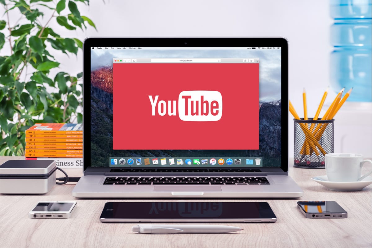 YouTube logo on a laptop sitting on a desk.