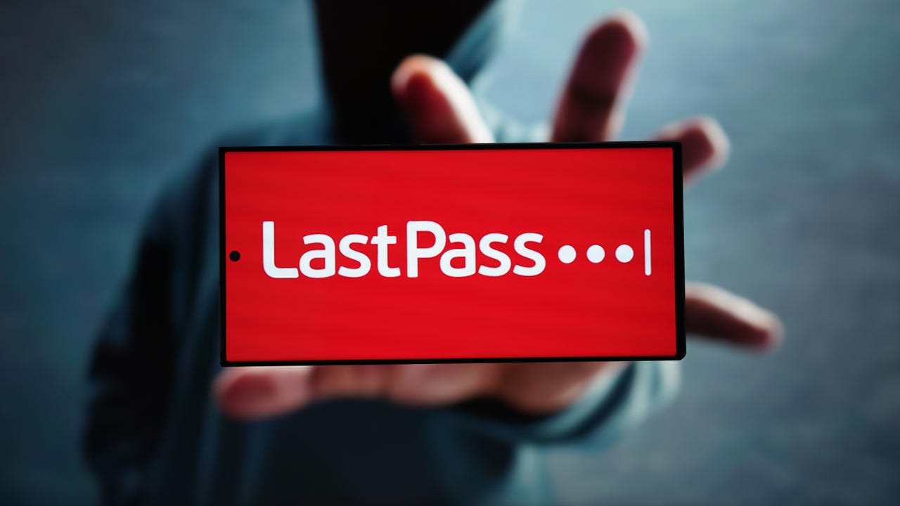 Thief reaching out to a phone showing the LastPass logo.