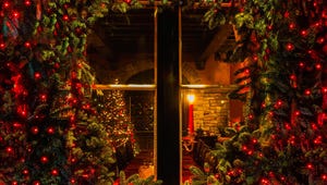 Christmas tree and fireplace seen through a wooden cabin window