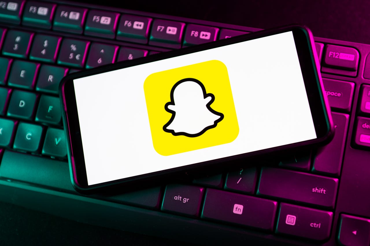 Snapchat logo on a smartphone sitting on a keyboard