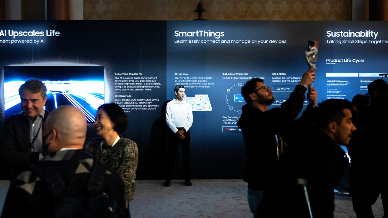 People walk past TV products at the Samsung First Look preview at the Caesars Palace resort a pre-show for this weeks Consumer Electronics Show January 7, 2024, in Las Vegas, Nevada. (Photo by Brendan Smialowski / AFP) (Photo by BRENDAN SMIALOWSKI/AFP via Getty Images)