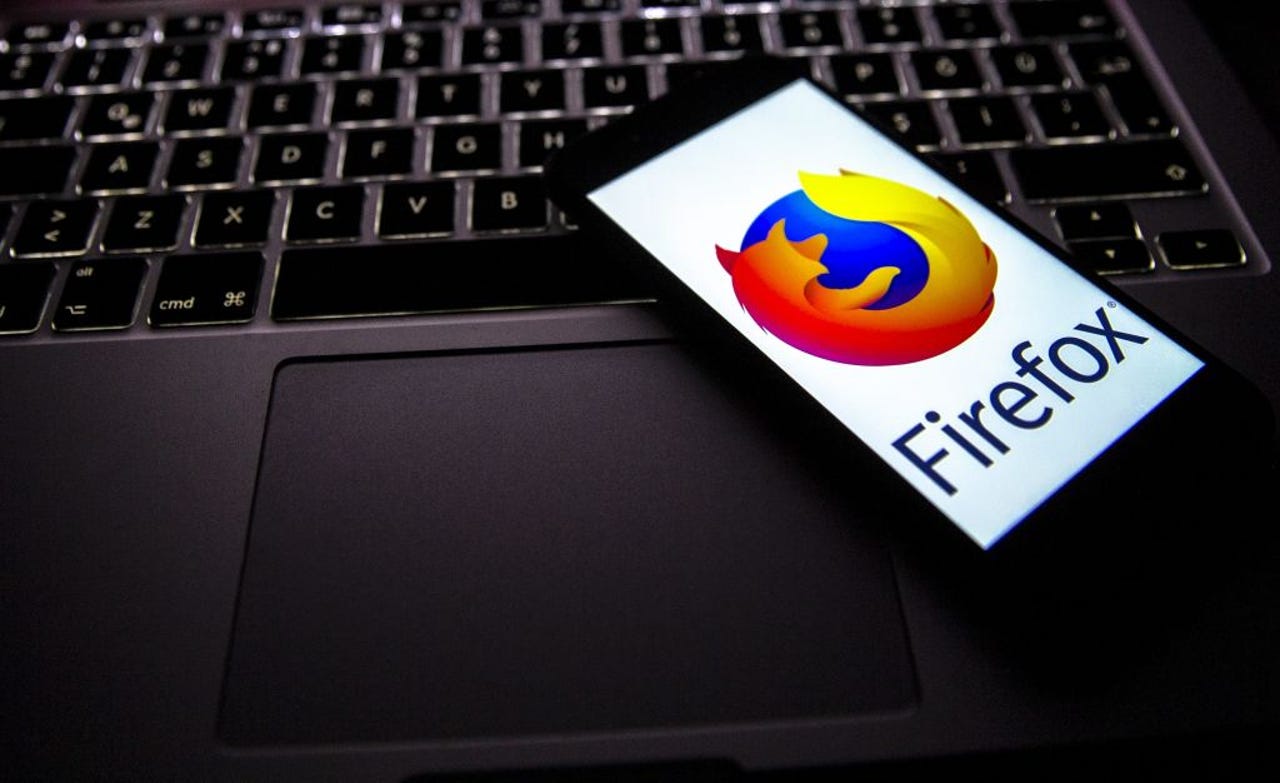 Firefox logo on phone lying on a laptop keyboard