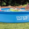 Family splashing in an inflatable pool outside