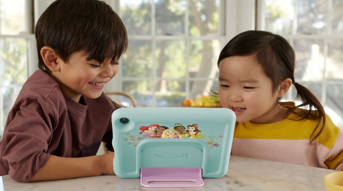 Two little kids looking at an Amazon kids tablet at a kitchen table