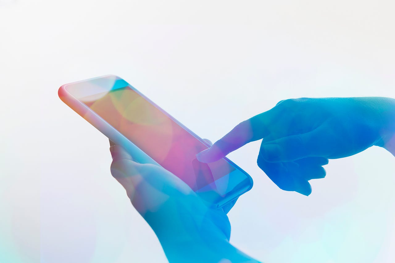 Colorful image of a person's finger touching a smartphone