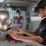 Woman wearing AR glasses headset working on a machine