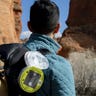 A Luci pro outdoor 2.0 is clipped onto a hiker's pack for easy charging