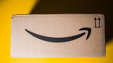 Amazon Prime cardboard box delivery yellow background