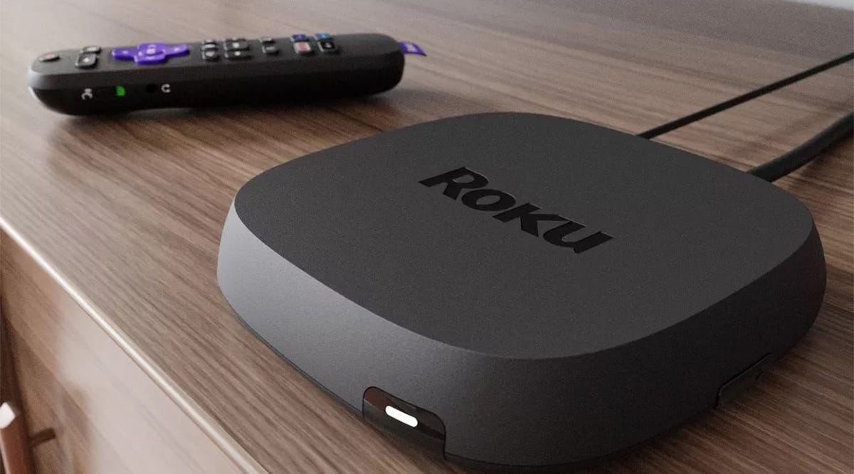 A Roku Ultra and its remote resting on a console table