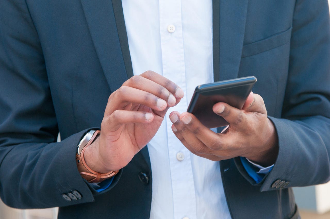 Closeup of mobile phone in business man hands