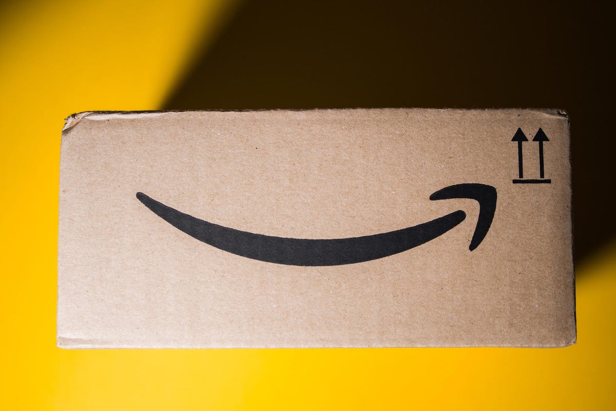 Pengiriman kotak karton Amazon Prime dengan latar belakang kuning