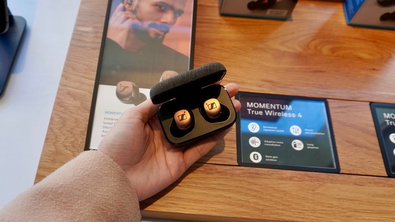The new Sennheiser Momentum 4 wireless earbuds in a woman's hand