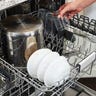 Person opening the top part of a dishwasher full of dishes
