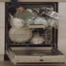 Person loading a dishwasher full of pots and pans