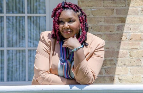Dr. Paige Gardner, a Black woman wearing professional clothing, poses next to a railing.