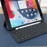 The iPad 9th gen tablet with an attached keyboard on a blue desk