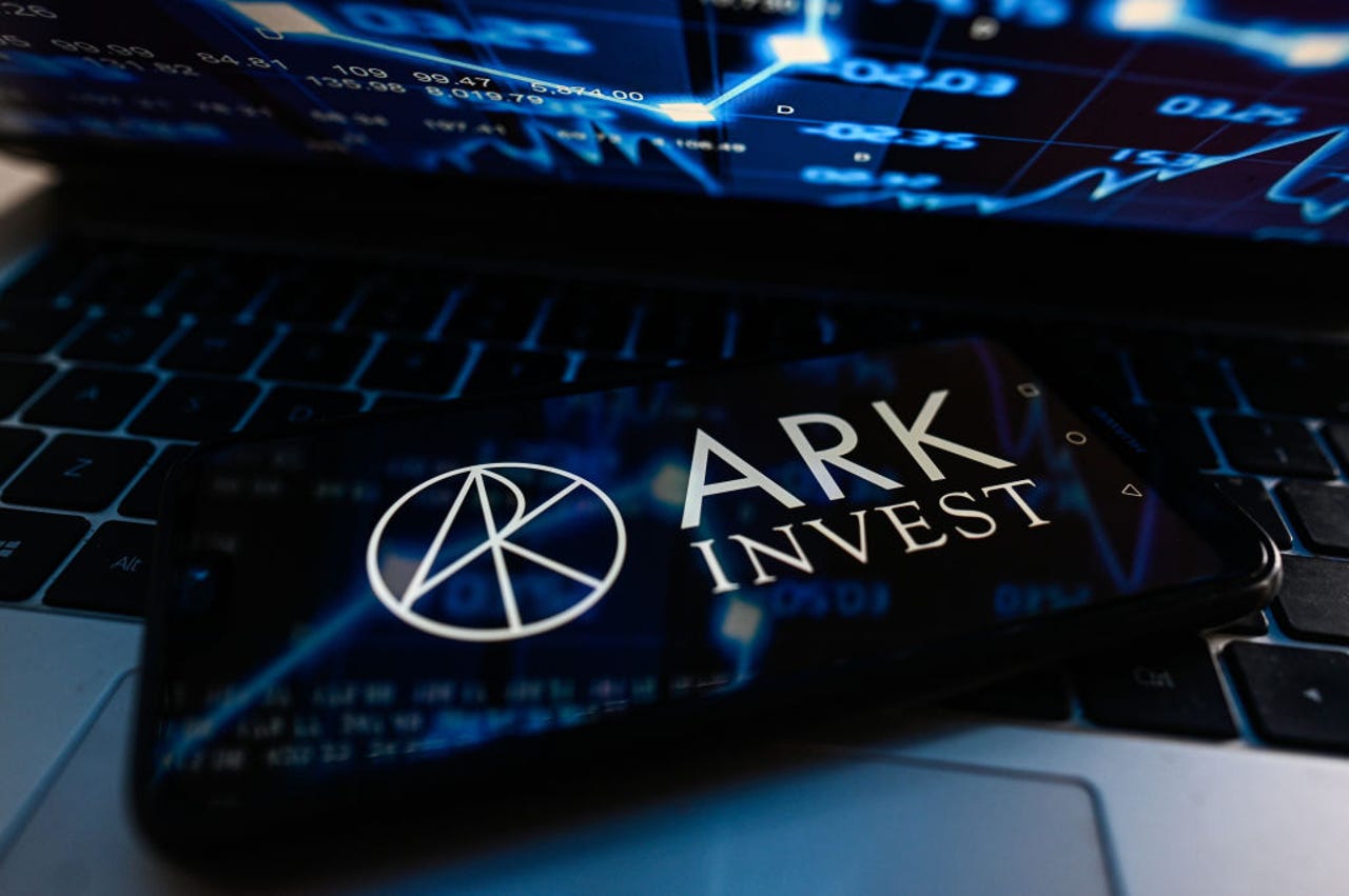 ARK Invest logo on phone balanced on keyboard