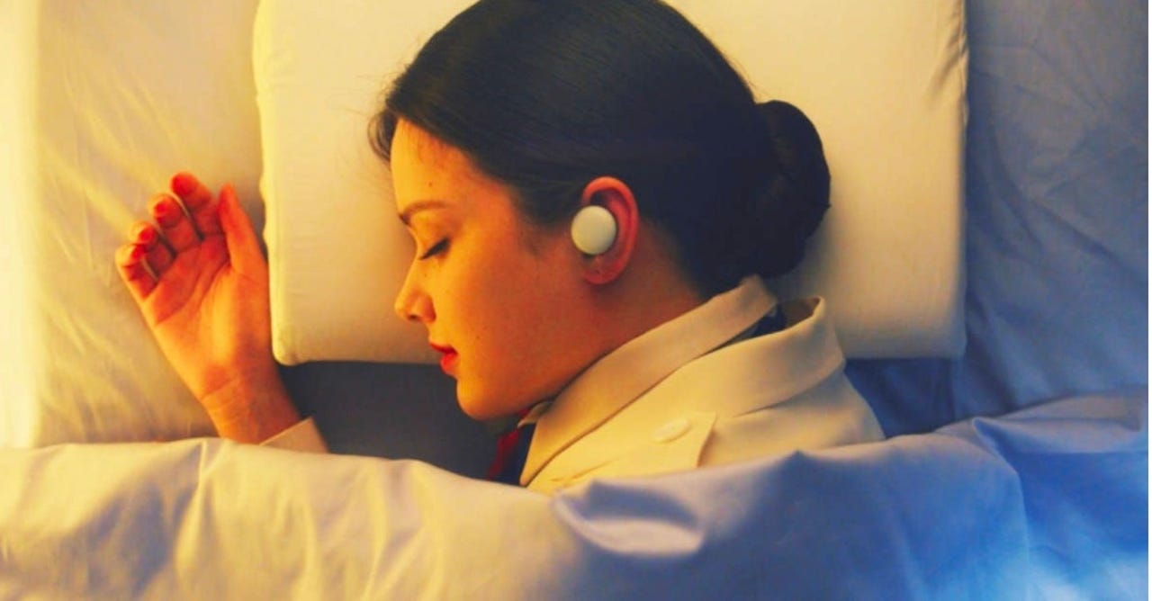Young woman sleeping on her side wearing LG Breeze earphones