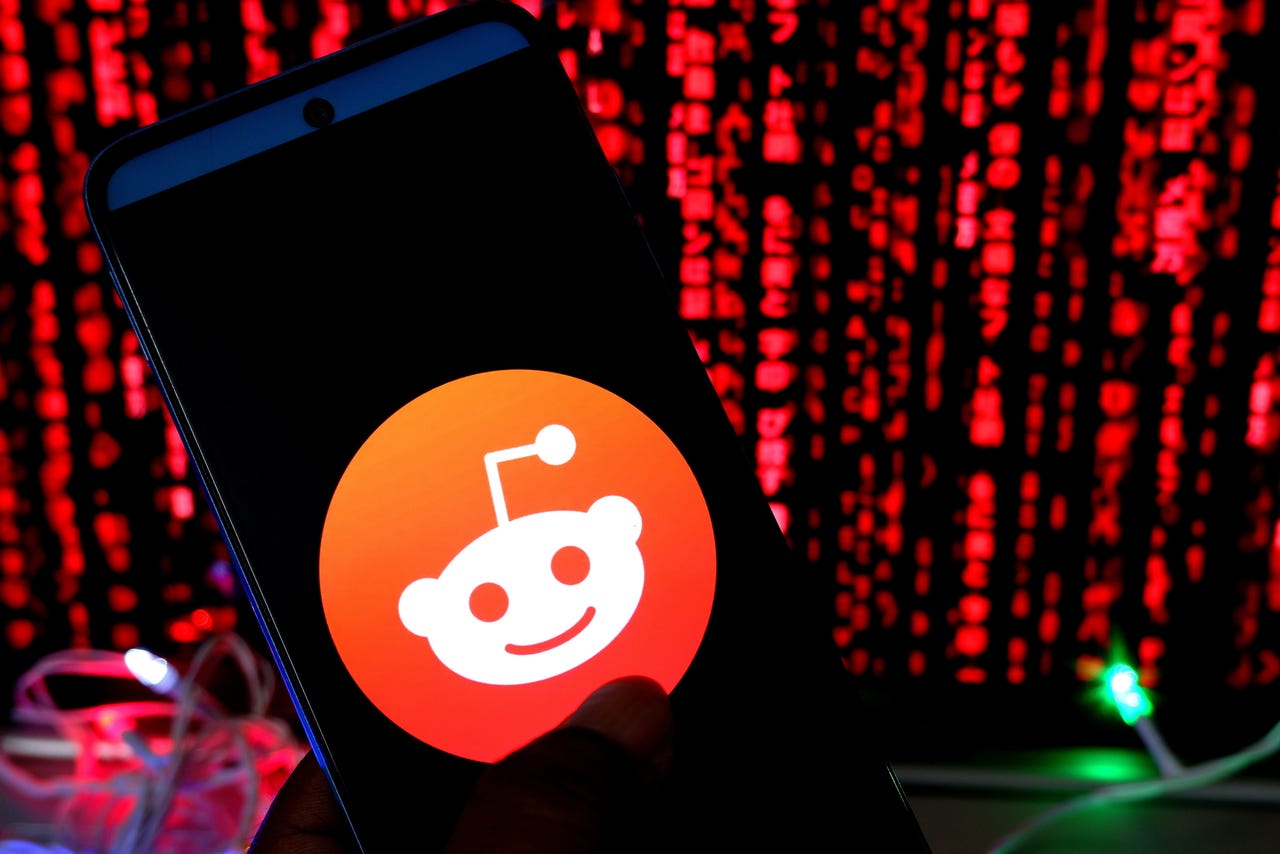 Reddit logo on a phone with cybersecurity in the background
