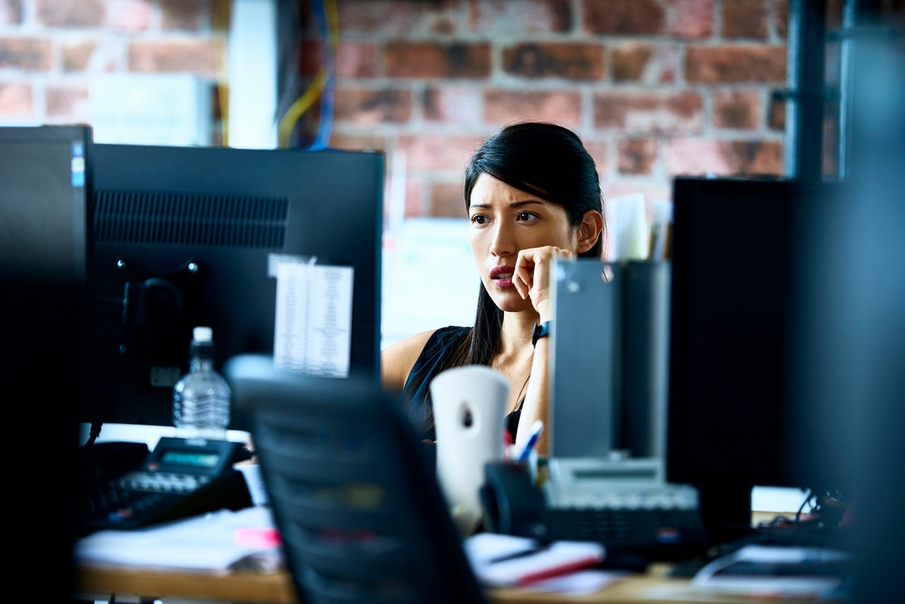worried woman working at computer in office