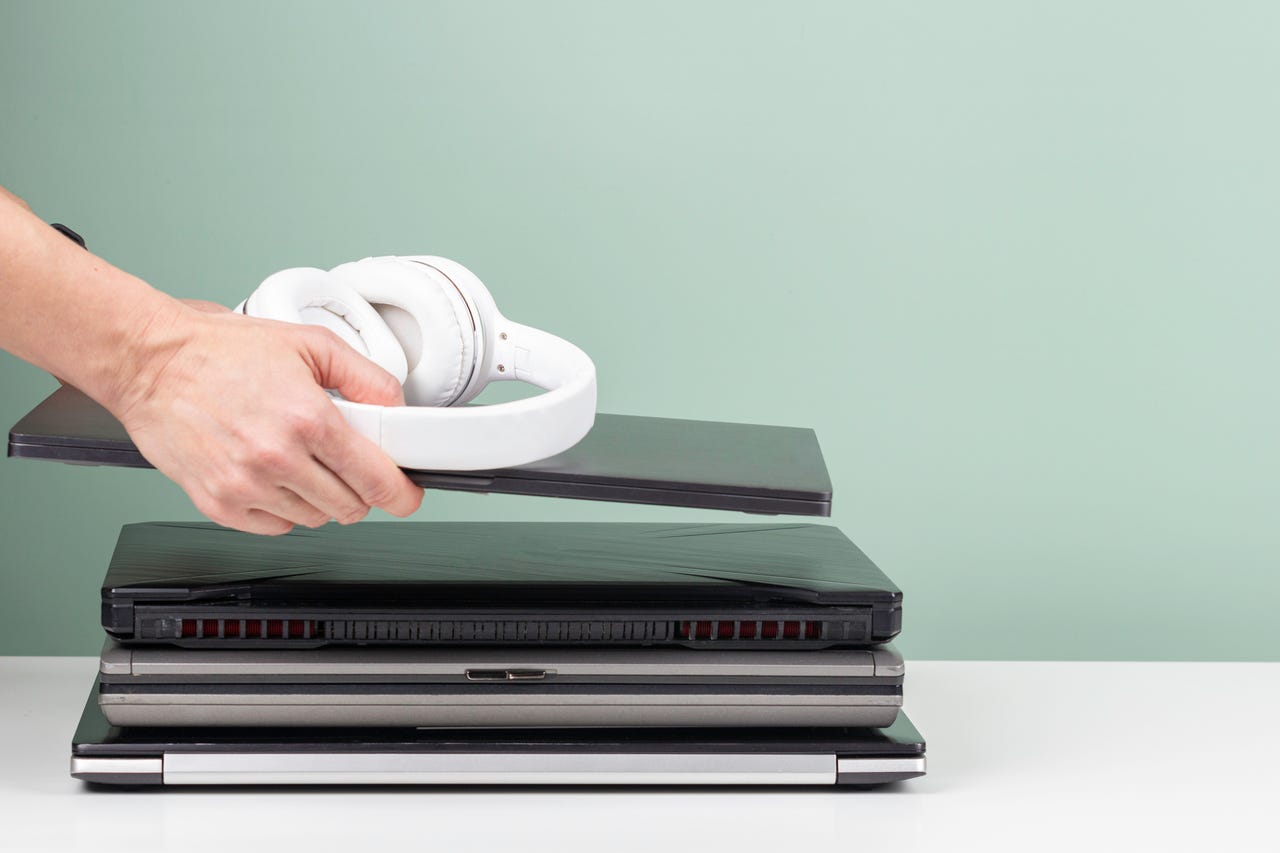 Person stacking old laptops