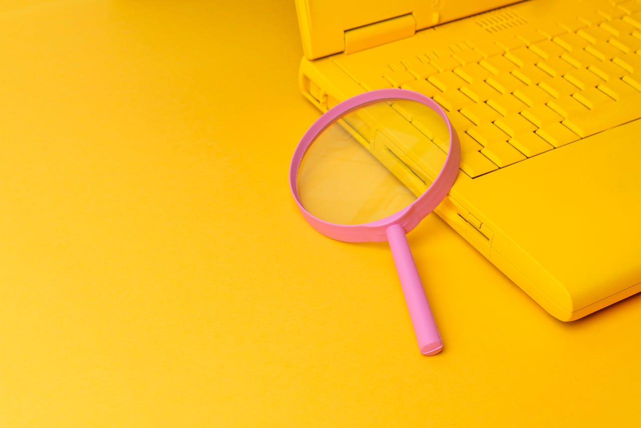 pink magnifying glass on laptop
