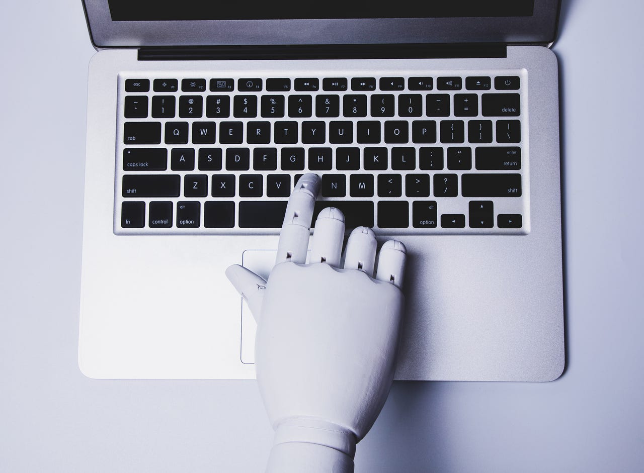 Robot hand typing on a keyboard