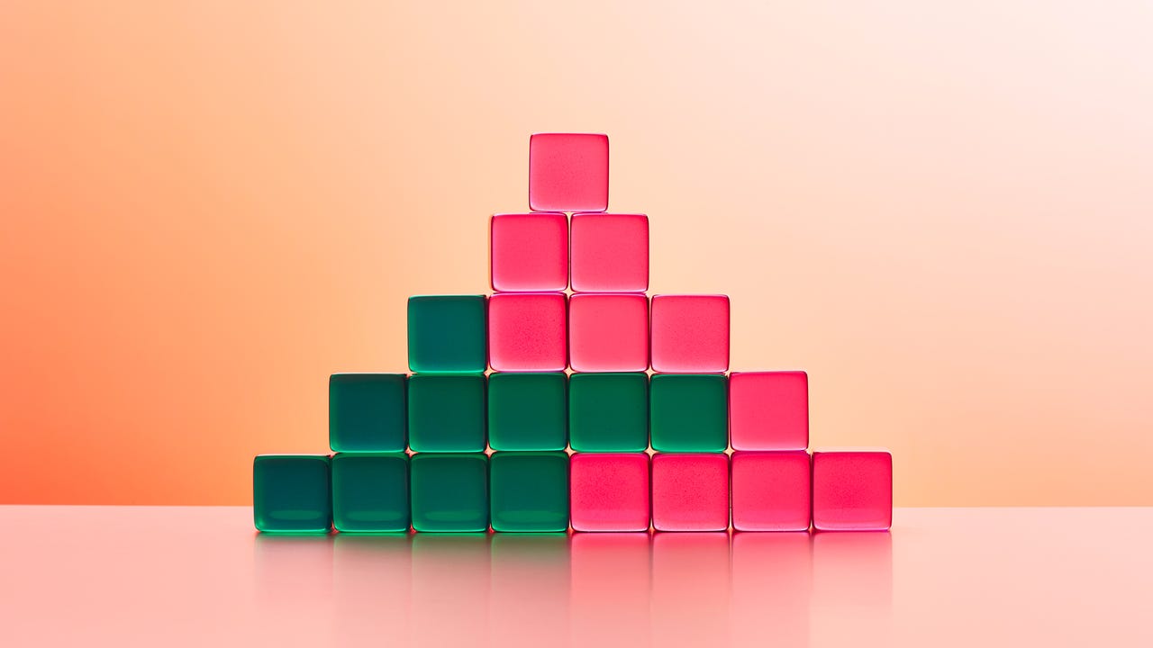 A triangular stack of interlocked pink and green blocks