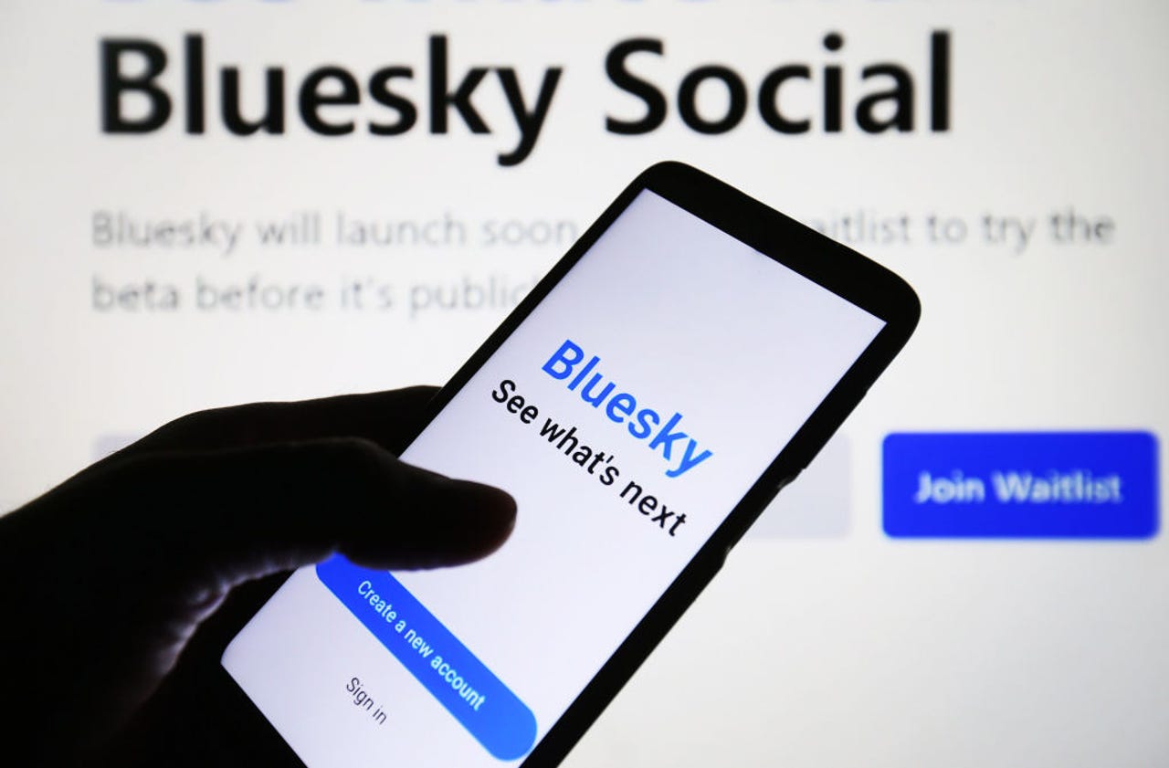 Person holding phone with Bluesky sign-in
