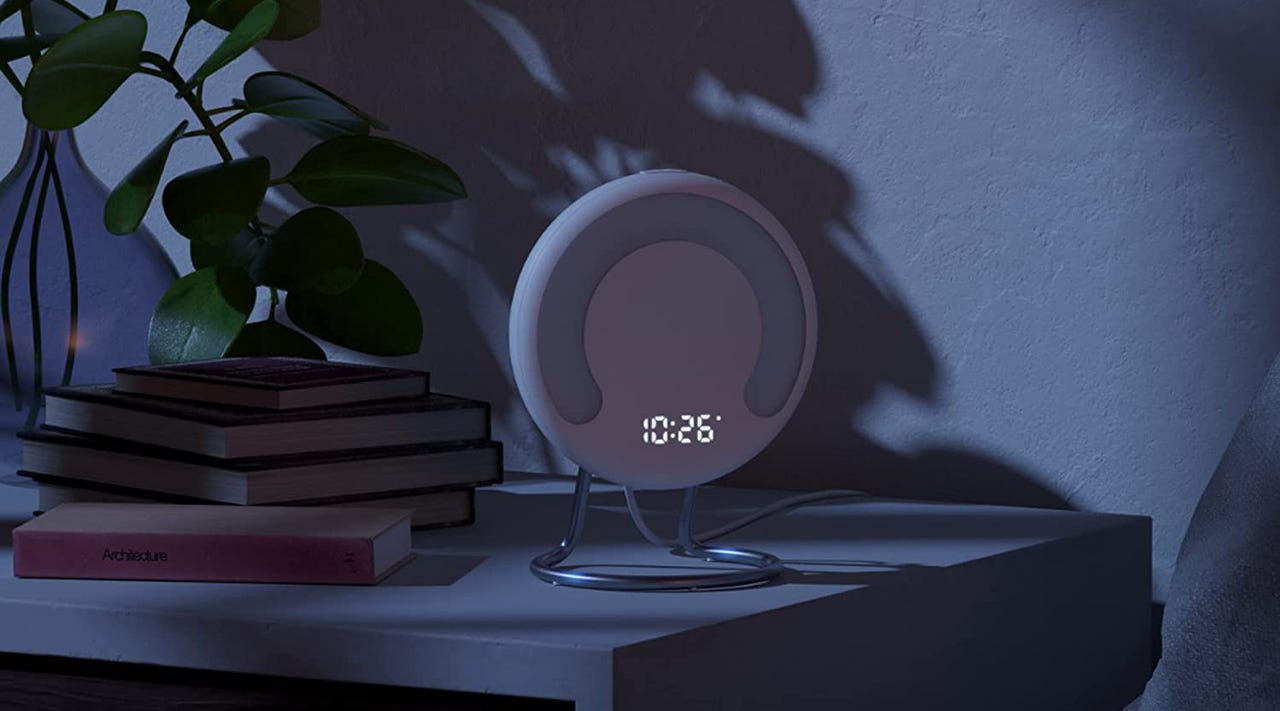 Image of a Halo Rise on a bedside table next to a plant at night