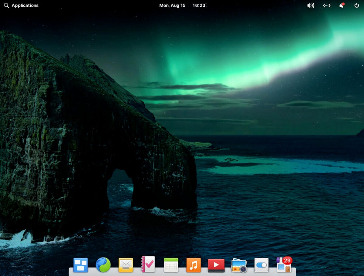 A área de trabalho padrão do Elementary OS, mostrando uma grande rocha oceânica e as luzes do norte