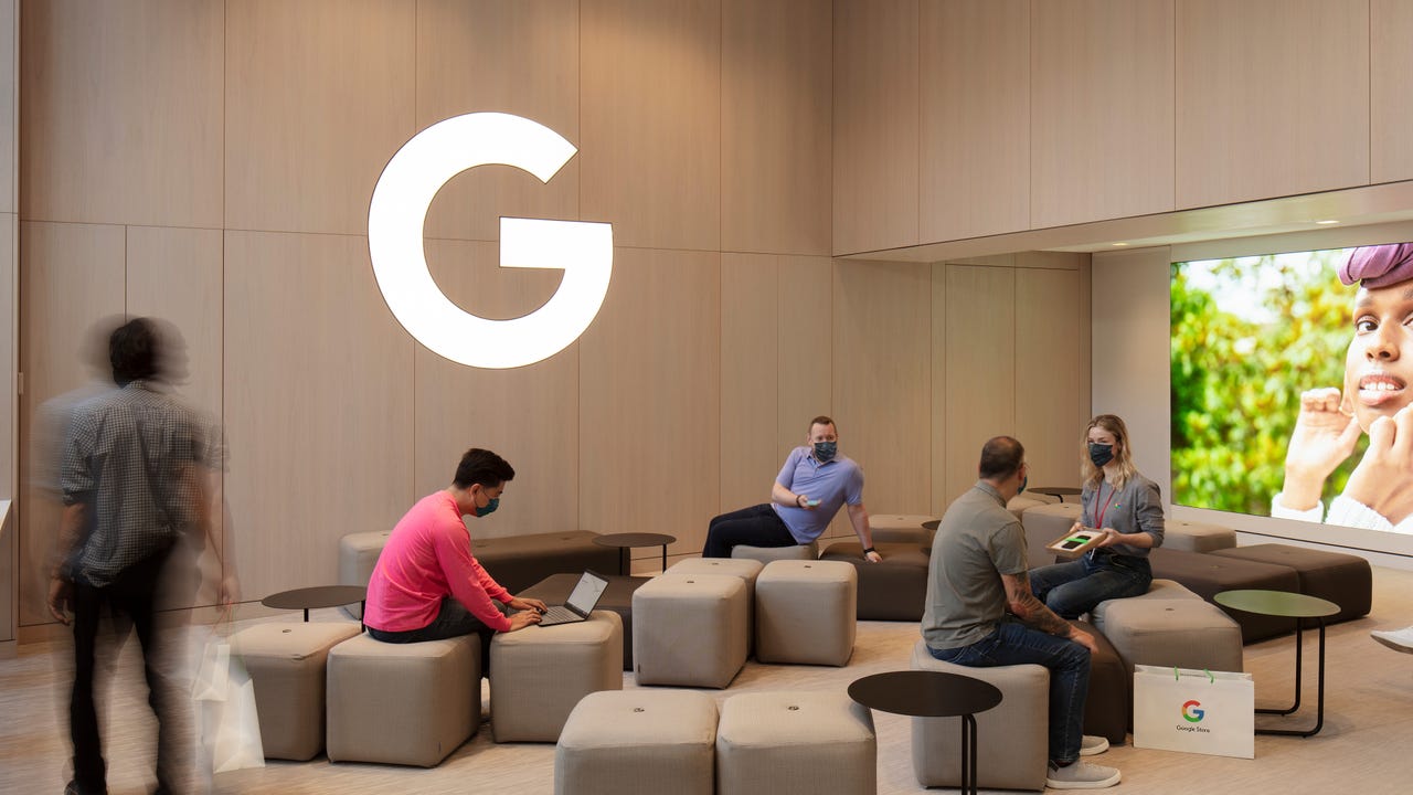 The interior of Google's NYC store with customers and workers interacting.