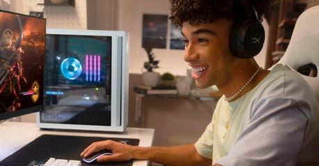 A teenage boy using an HP OMEN 25L gaming PC to play a video game set in space.