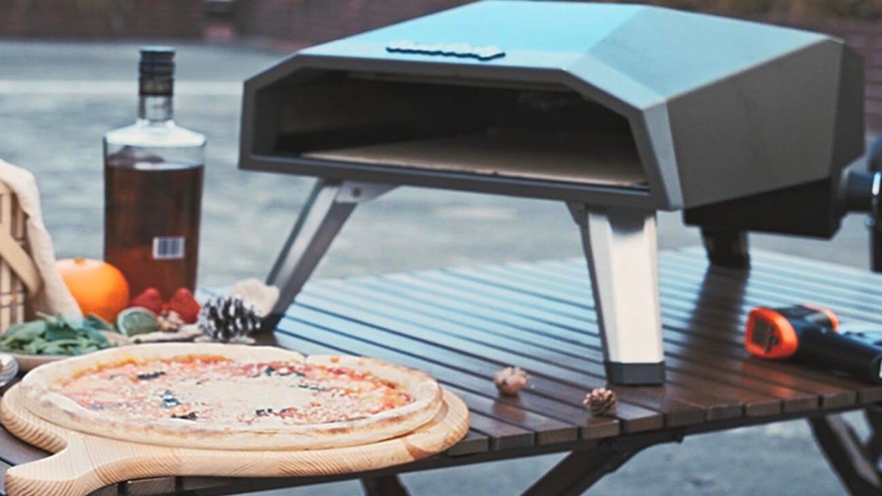 Pizza oven with a cooked pizza next to it