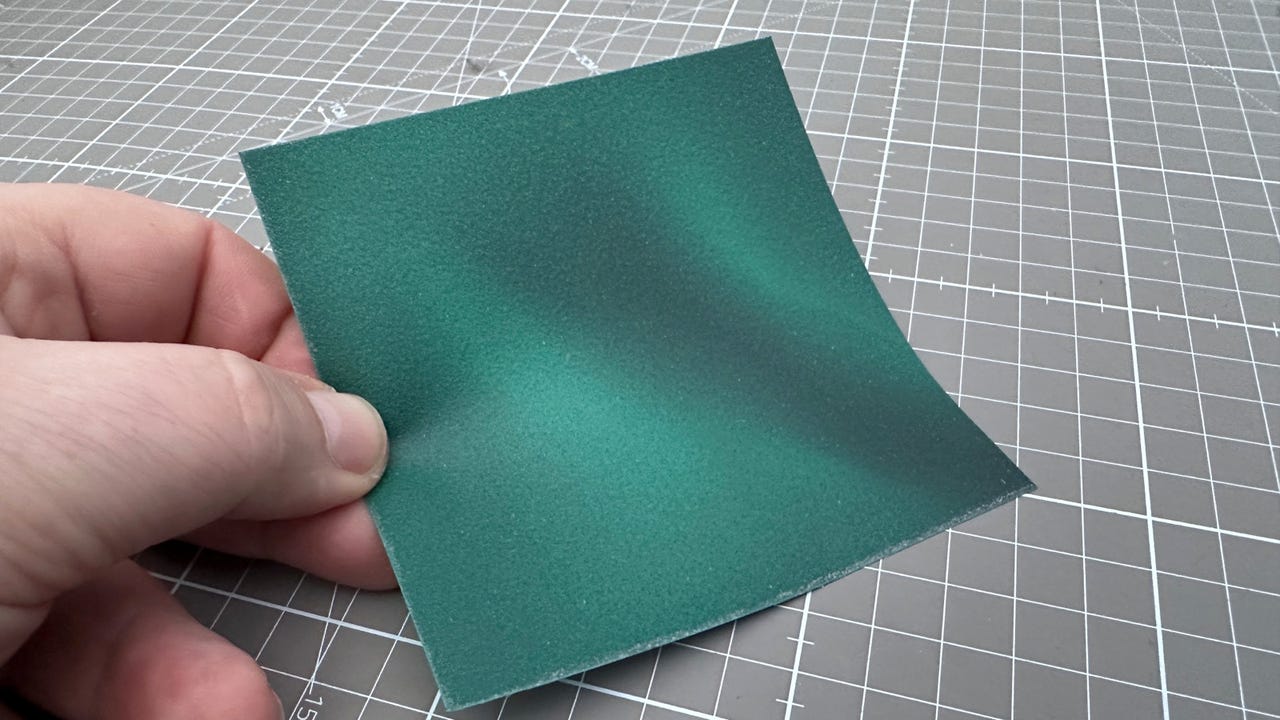 Small green square of magnetic viewing film held in fingers