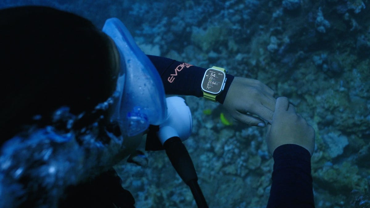Close-up of a scuba diver using an Apple Watch Ultra underwater