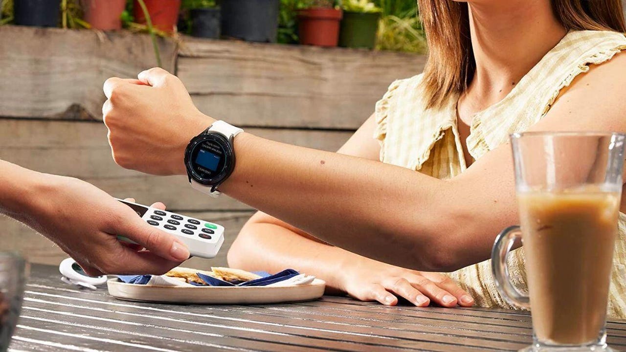 Woman sitting at a table and displaying the smart watch on her wrist