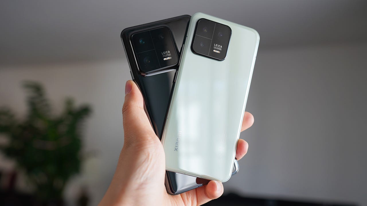 Holding up the Xiaomi 13 and 13 Pro.