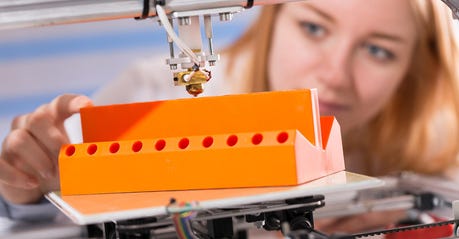 A female student or laboratory assistant in the automation laboratory is debugging the work of the 3d printer. 3d printer is a device for modeling 3D objects