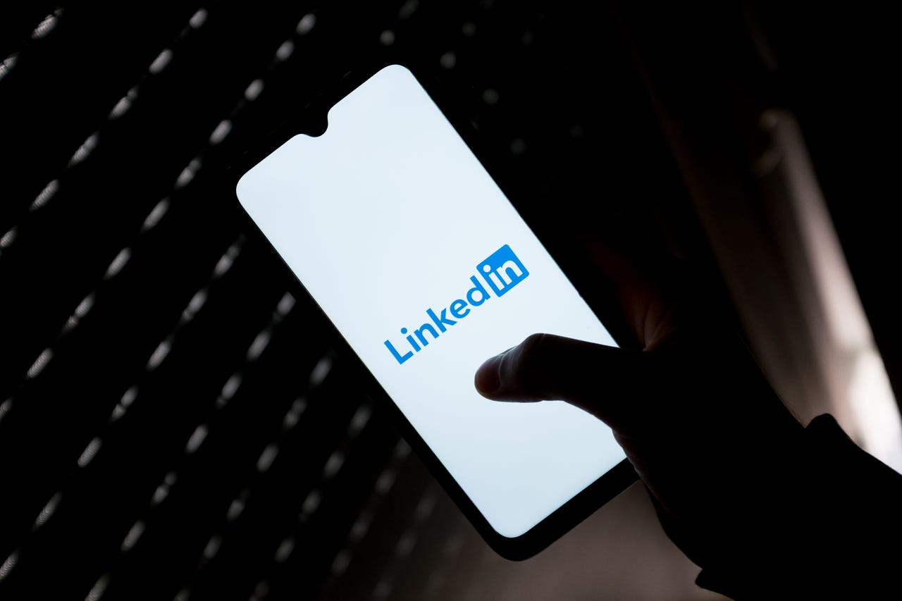 LinkedIn logo on a phone in front of a keyboard