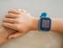 Close up of a kid's arm with a blue smartwatch on it