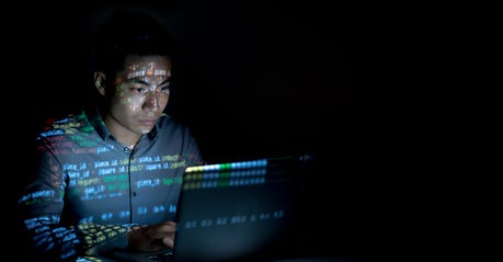 man looking at a screen in a dark room