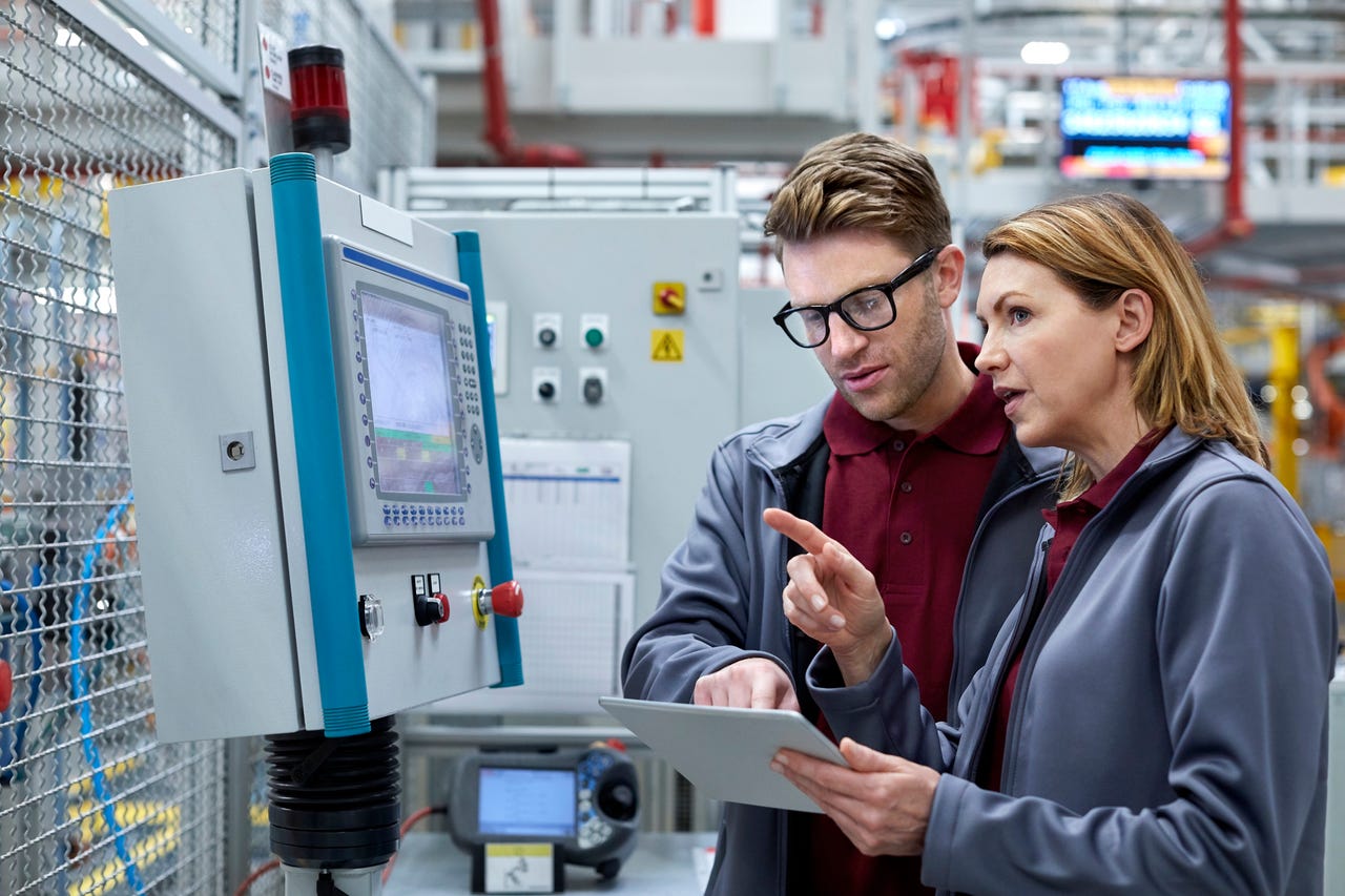 engineers-looking-at-computer-systems-in-a-factory