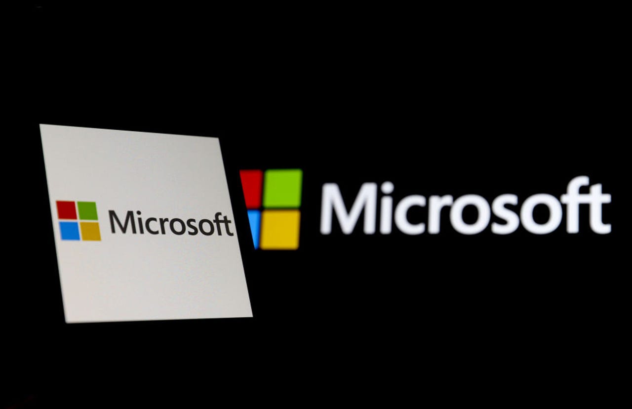Microsoft logo on black background with Microsoft on white screen next to it