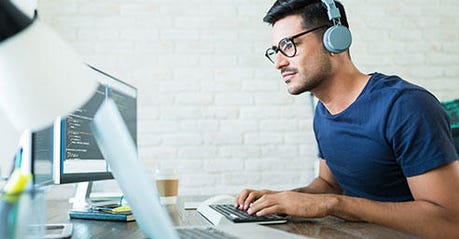 Latin Freelance Coding Expert Using Computer At Desk