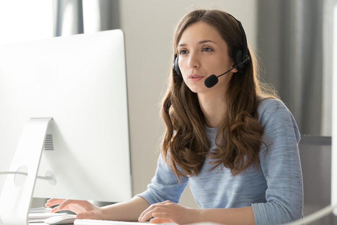 Businesswoman in headset call center agent consulting participating video conference.