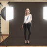 A young woman standing between two Neewer Professional softbox lights